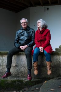 man and woman sitting on wall